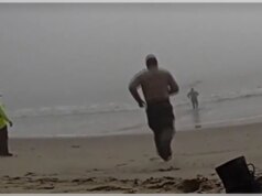 Deputados de Los Angeles capturados pela câmera correndo em direção ao oceano nebuloso para resgatar parapentes desorientados